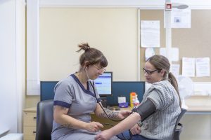 Nurse checking patients blood pressure in doctors office